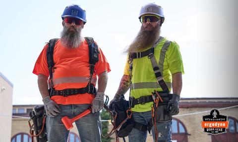 Two workers wearing tool tethering belts while working on a rooftop